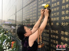 唐山大地震42年祭日，一名幸存者用鲜花祭奠自己罹难的亲人。