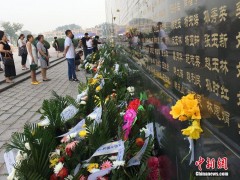 7月28日，市民在唐山大地震纪念墙前追思亲人。当日是唐山大地震42周年纪念日，人们来到唐山大地震纪念墙前，摆放鲜花，祭奠亲人。