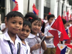 菲律宾总统府外，当地少年手持两国国旗热情欢迎习近平主席访问菲律宾。 人民日报记者 汪晓东 摄